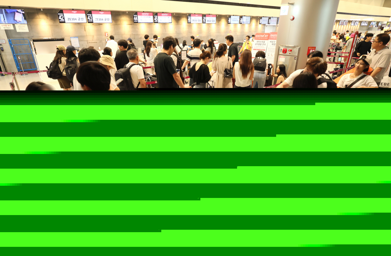 Passengers crowd in front of the ticketing counter of Eastar Jet at Jeju International Airport following the massive disruption to Microsoft systems, Friday. (Yonhap)