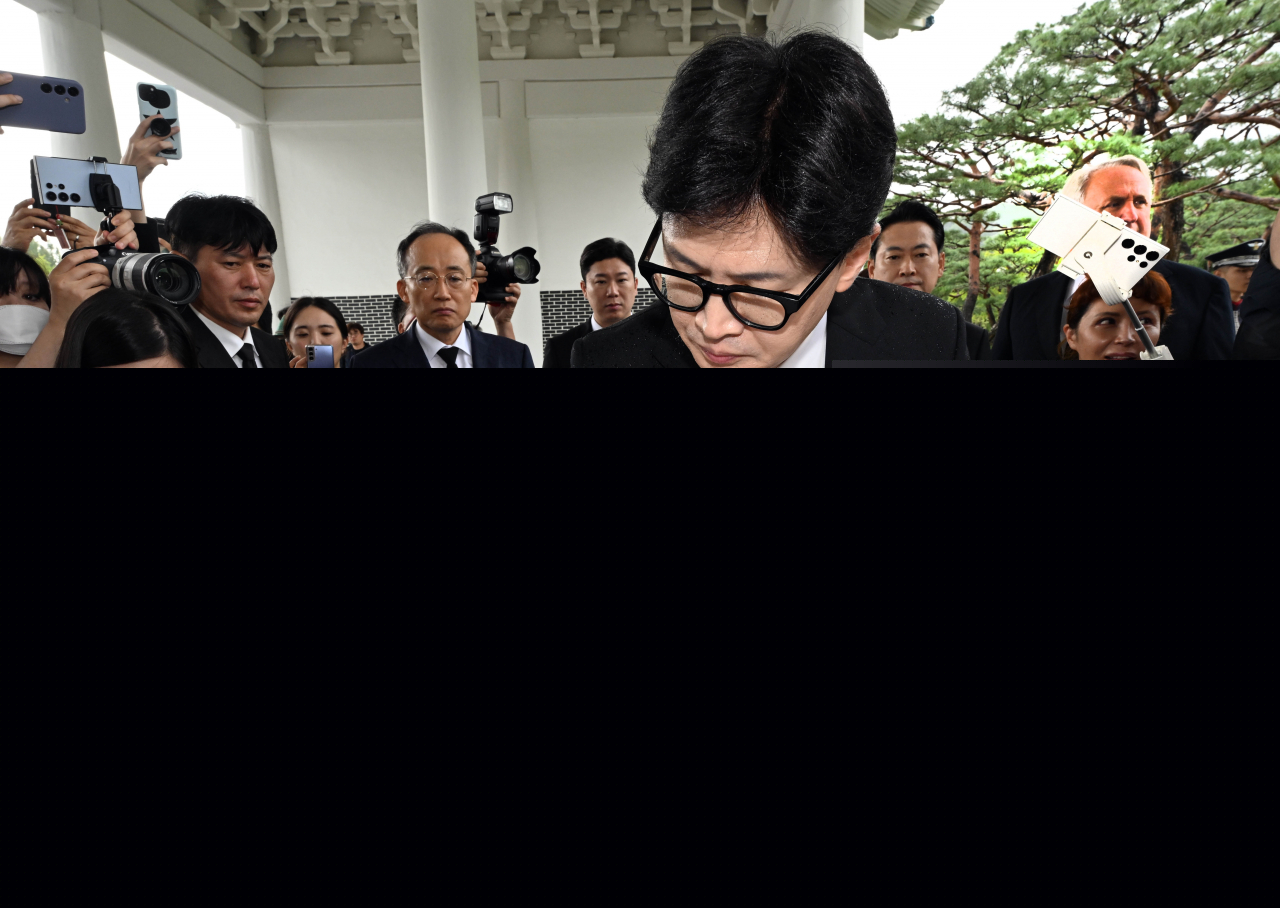 People Power Party Chair Han Dong-hoon writes a message on a guestbook as he visited the Seoul National Cemetery in Seoul on Wednesday. (Yonhap)