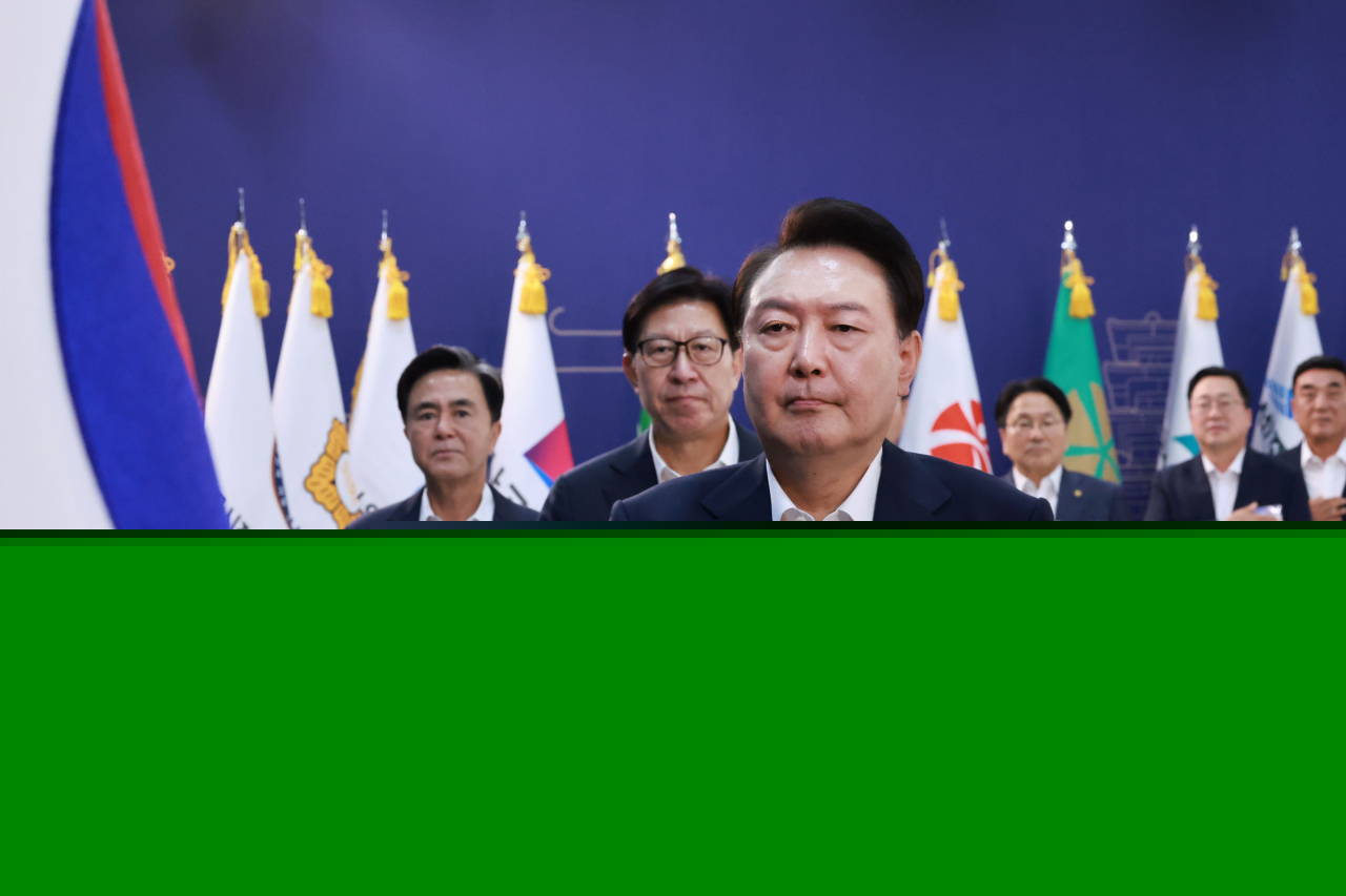 President Yoon Suk Yeol (third from left) salutes to the national flag as he presided over a meeting with heads of local autonomous governments in Hongseong-gun, South Chungcheong Province, Thursday. (Yonhap)