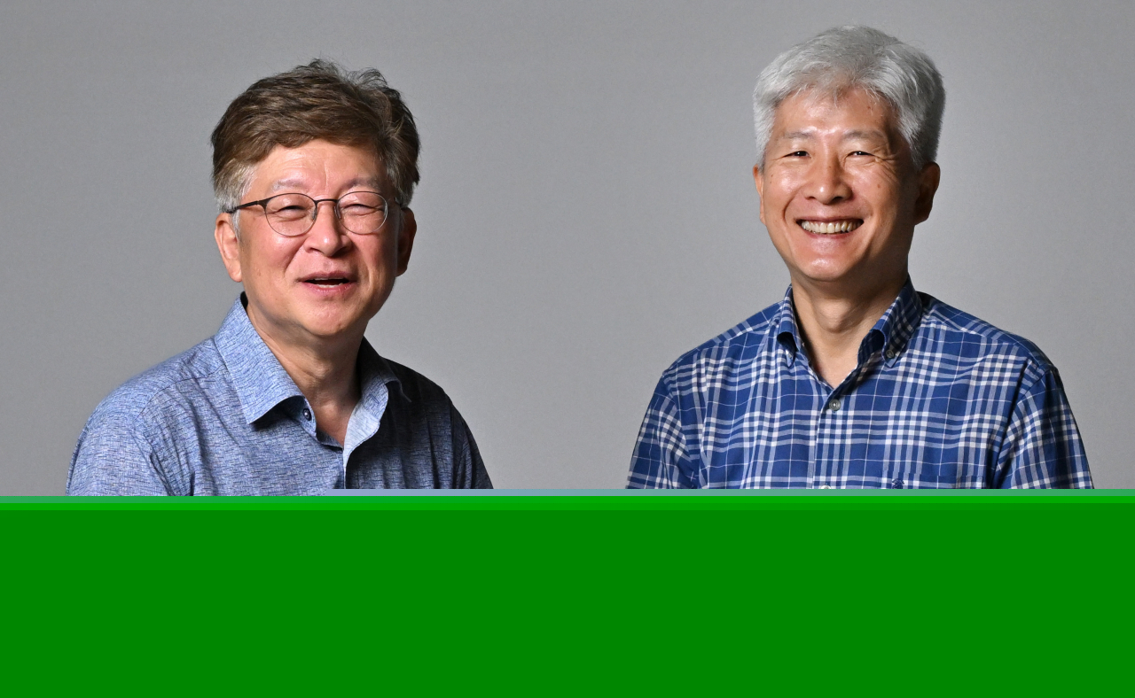 Kang Sung-jin, an economics professor at Korea University (left), and Jung Tae-yong, a professor at Yonsei University’s Graduate School of International Studies, pose for a photo during a round table meeting exploring Mongolia's business potential at Herald Square in Seoul on July 24. (Im Se-jun/The Korea Herald)