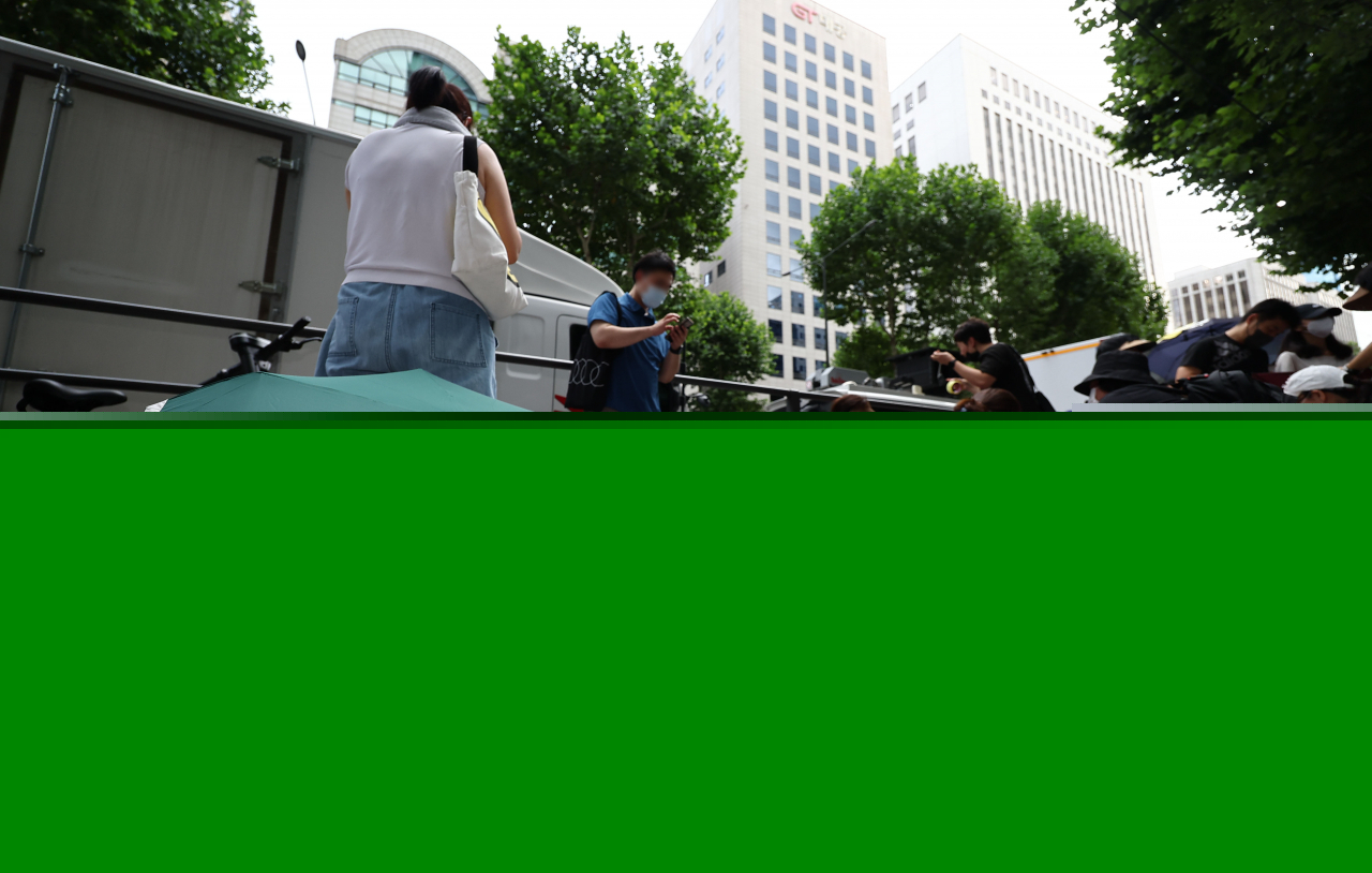 Consumers suffering from delayed payments from e-commerce platforms Tmon and WeMakePrice stage an umbrella protest, calling for apology and measures to recover damage, in front of the two platforms' owner Qoo10 headquarters in Seoul on Sunday. (Yonhap)